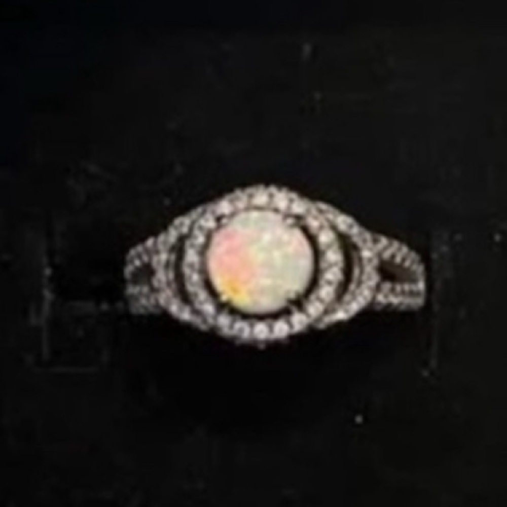 Woman’s Sterling silver ring. Opal -like stone and many CZ stones. Size 5
